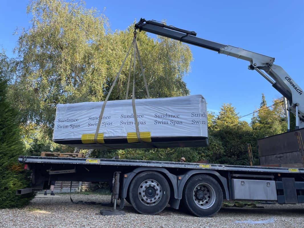 Swim spa being craned off lorry, in Ferndown, Dorset.